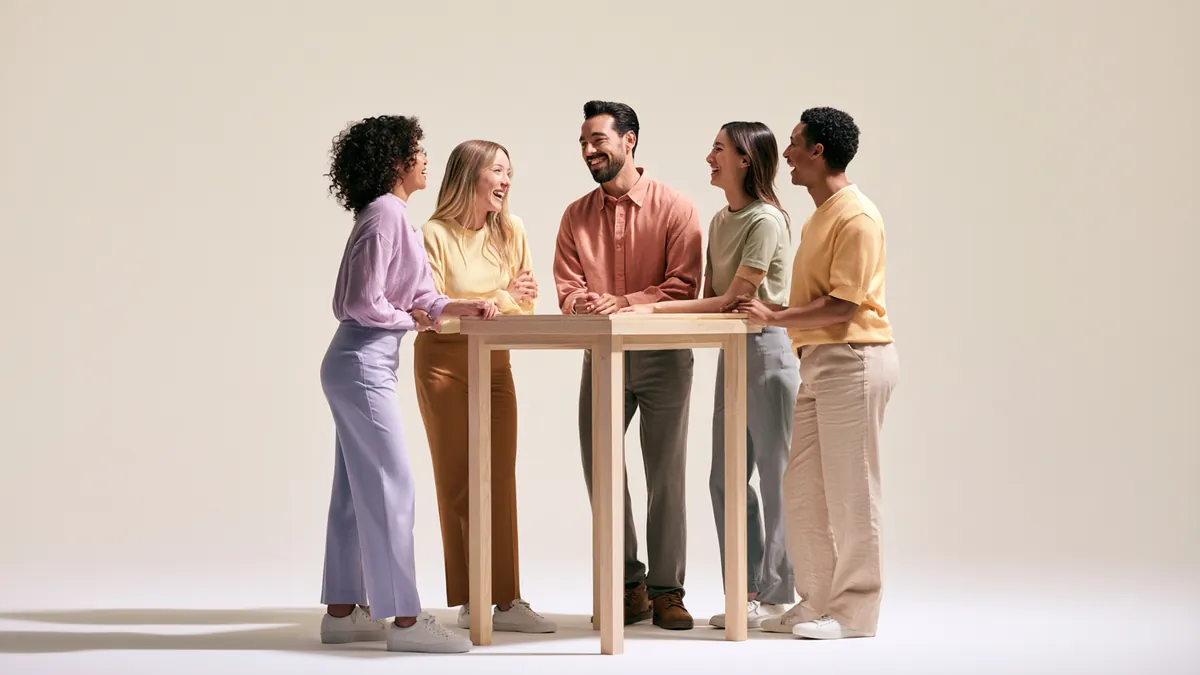 Diverse group of five coworkers smiling in a studio, representing the Happy Money Loan team — Happy Money personal loans.